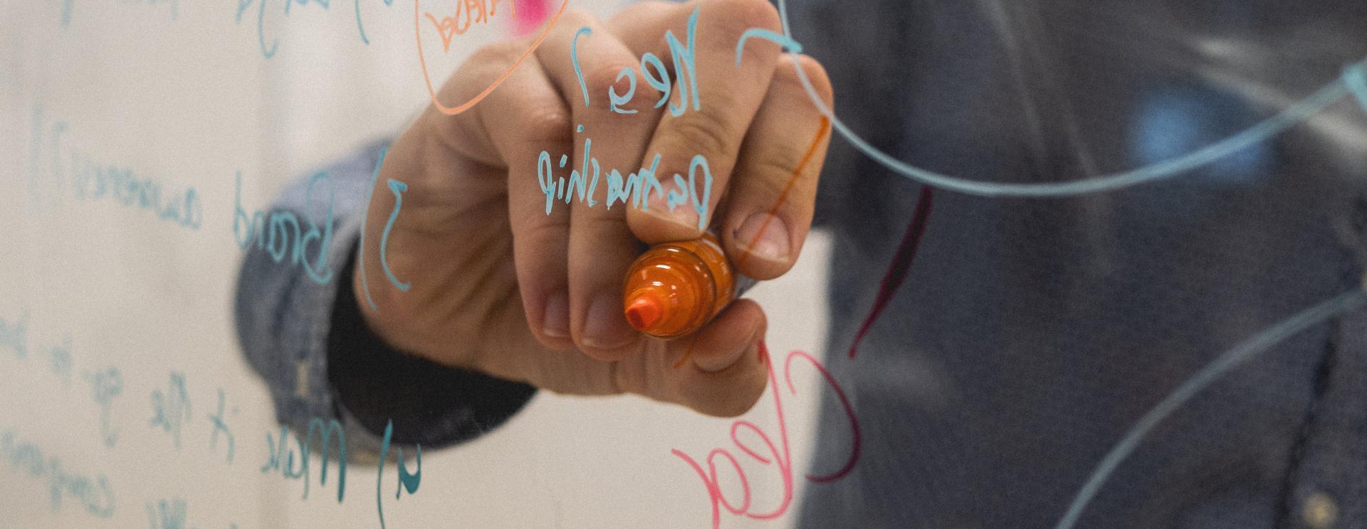 Vue d'une personne écrivant du code informatique sur un tableau