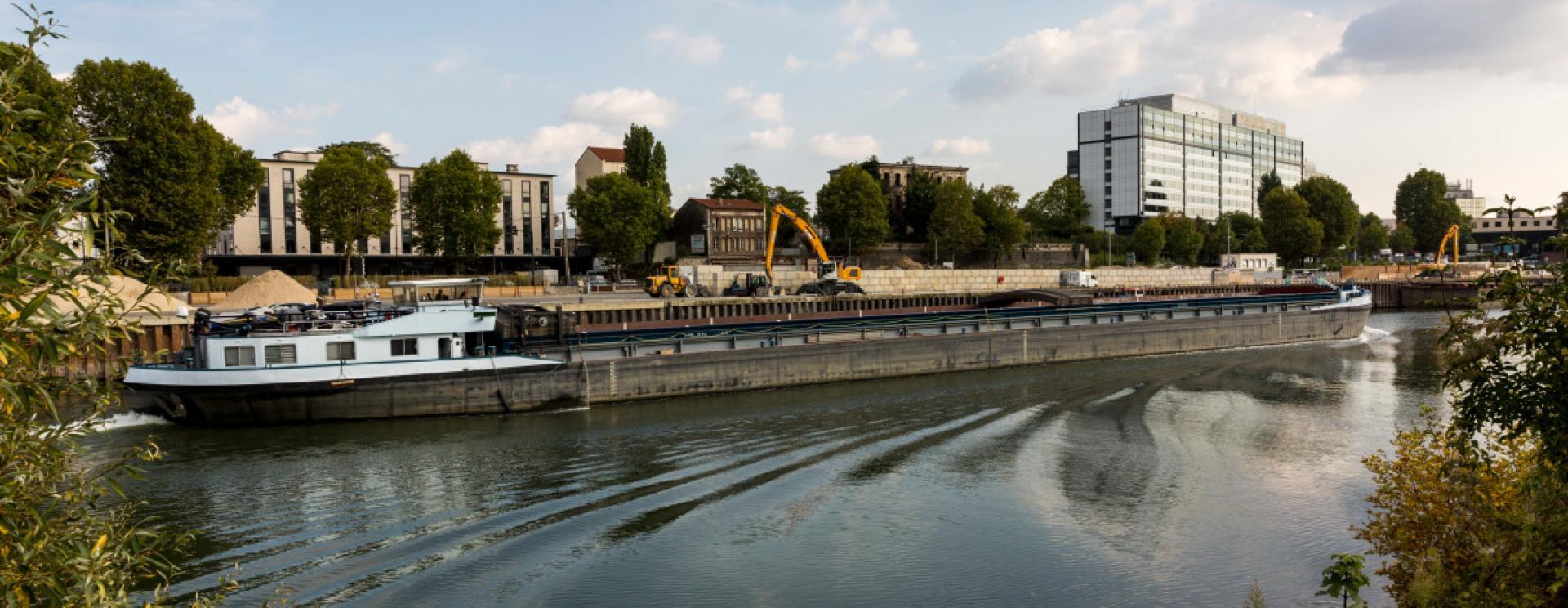 barge fluviale passant devant le quai à usage partagé du port de Saint-Denis l'Etoile en Seine aval