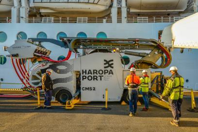 scène de branchement électrique d'un paquebot de croisière à quai grâce à un véhicule équipé de câbles de raccordement. - Enlarge image, modal window