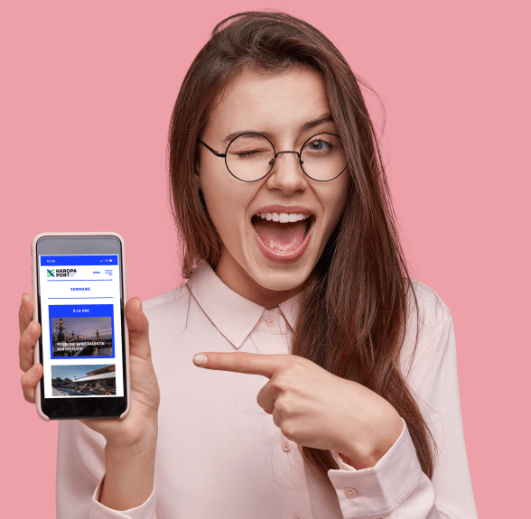 Jeune fille montrant un smartphone connecté sur l’application HAROPA PORT - Agrandir l'image, fenêtre modale